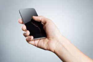 Hand Holding A Black Smartphone On White Background
