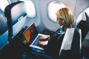 A Lady Using Her Laptop On An Airplane