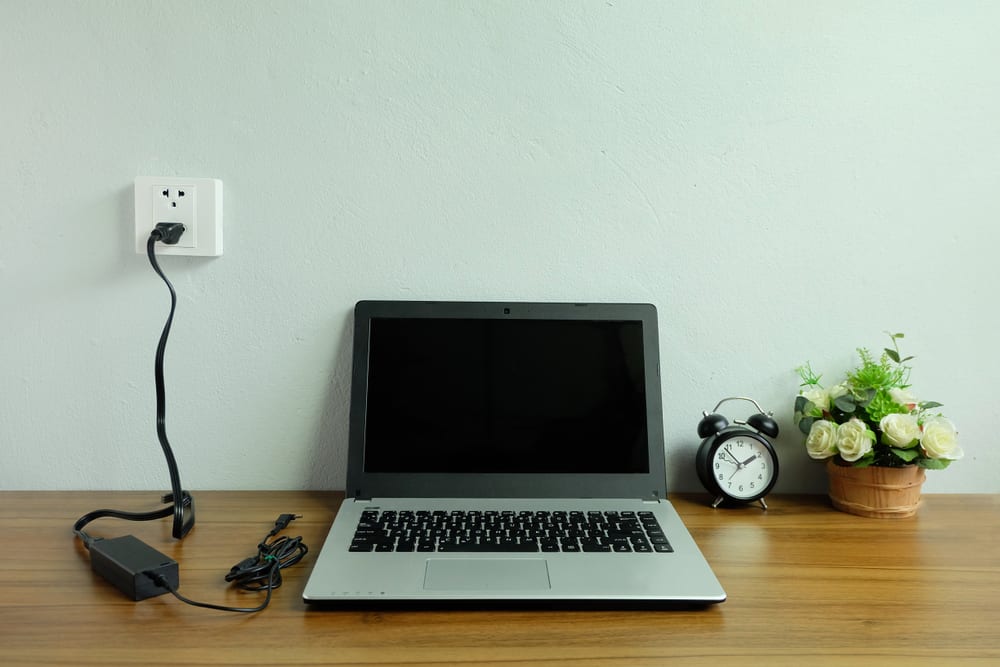 Laptop On A Desk With A Charger Plugged In
