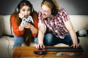 Two People Playing With A Game Controller And Keyboard