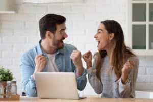 Man And Woman Excited At Laptop