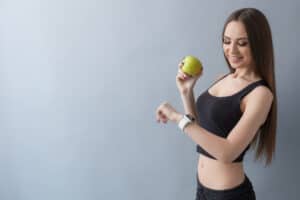 Lady With Apple Fruit Looking At Apple Watch