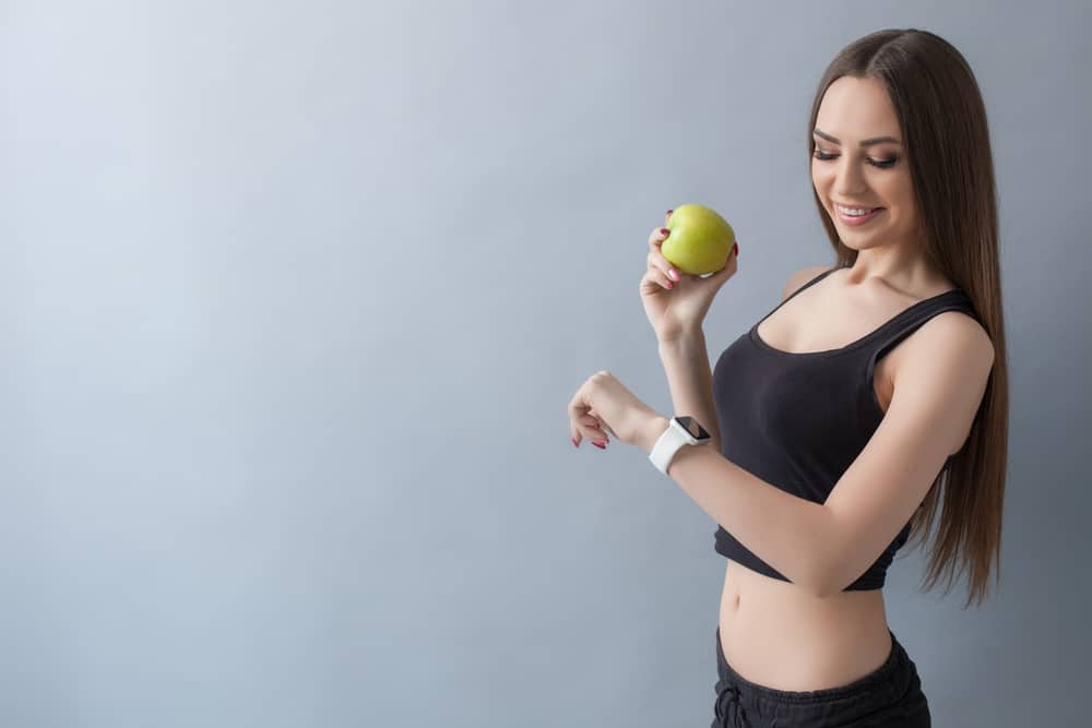 Lady With Apple Fruit Looking At Apple Watch