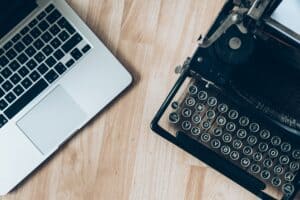 Macbook Beside A Typewriter